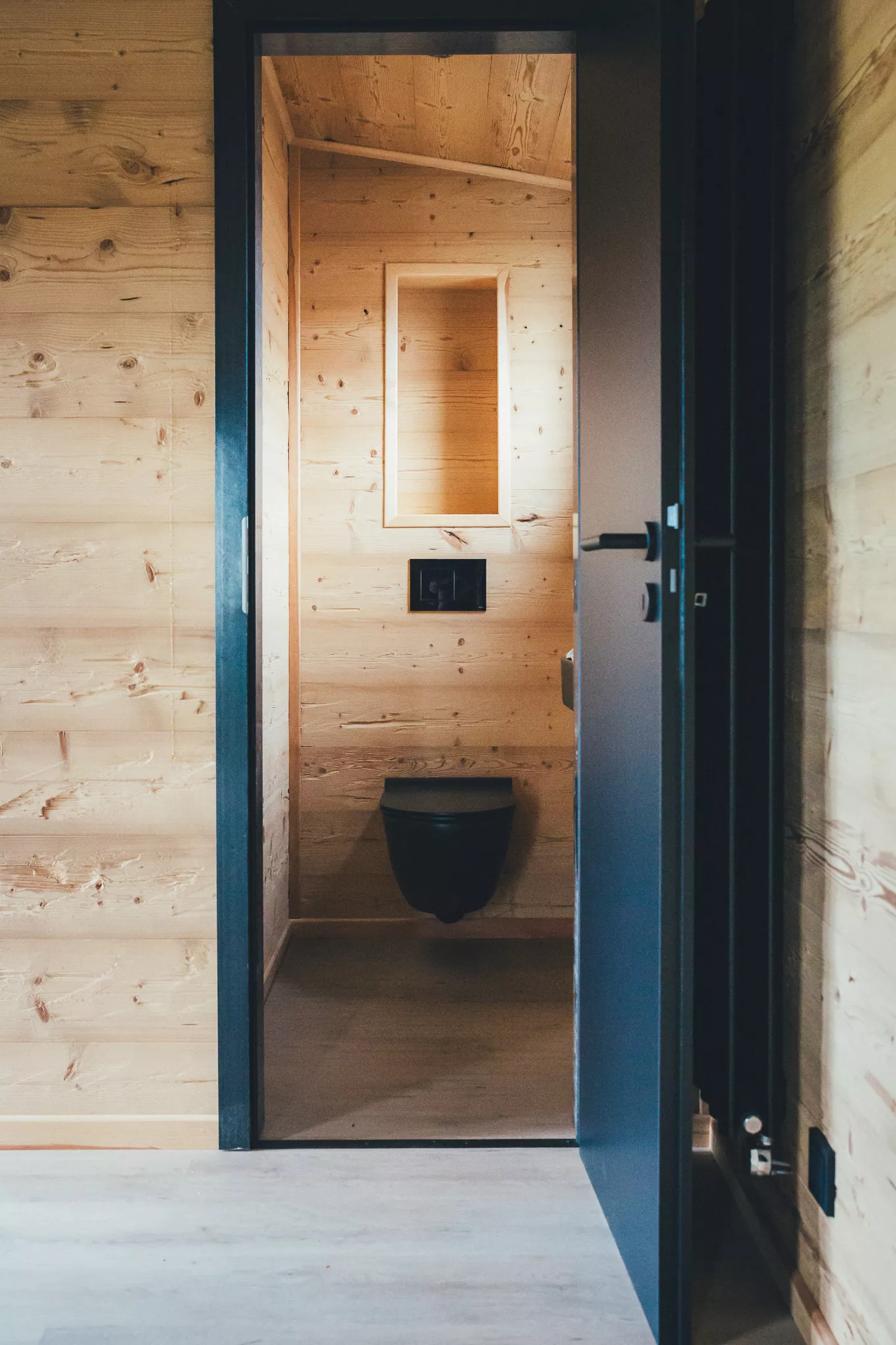 Kleines Bad im Tiny House mit wandhängendem WC und Holzverkleidung