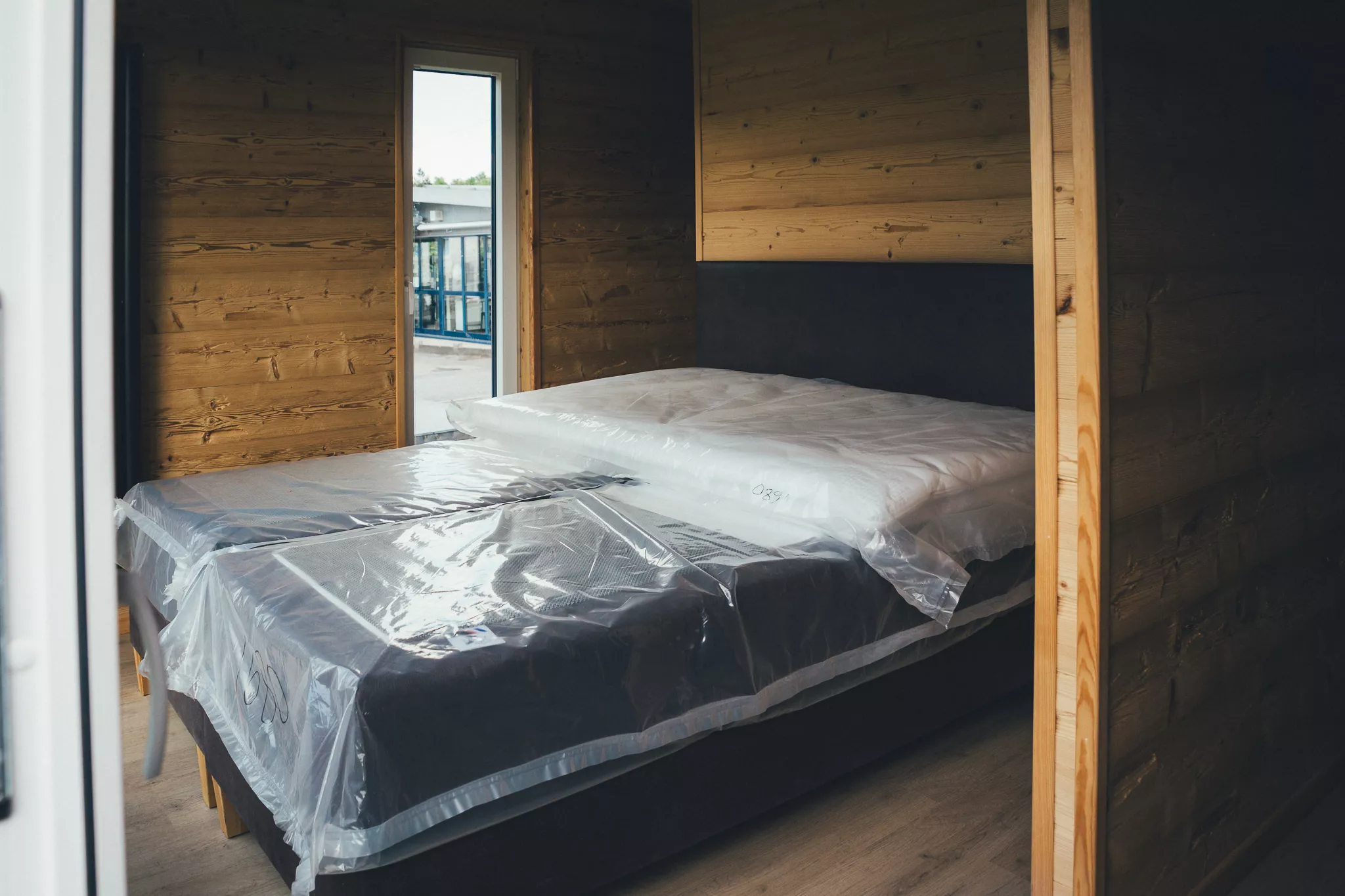Schlafbereich im Tiny House mit Doppelbett und Holzverkleidung