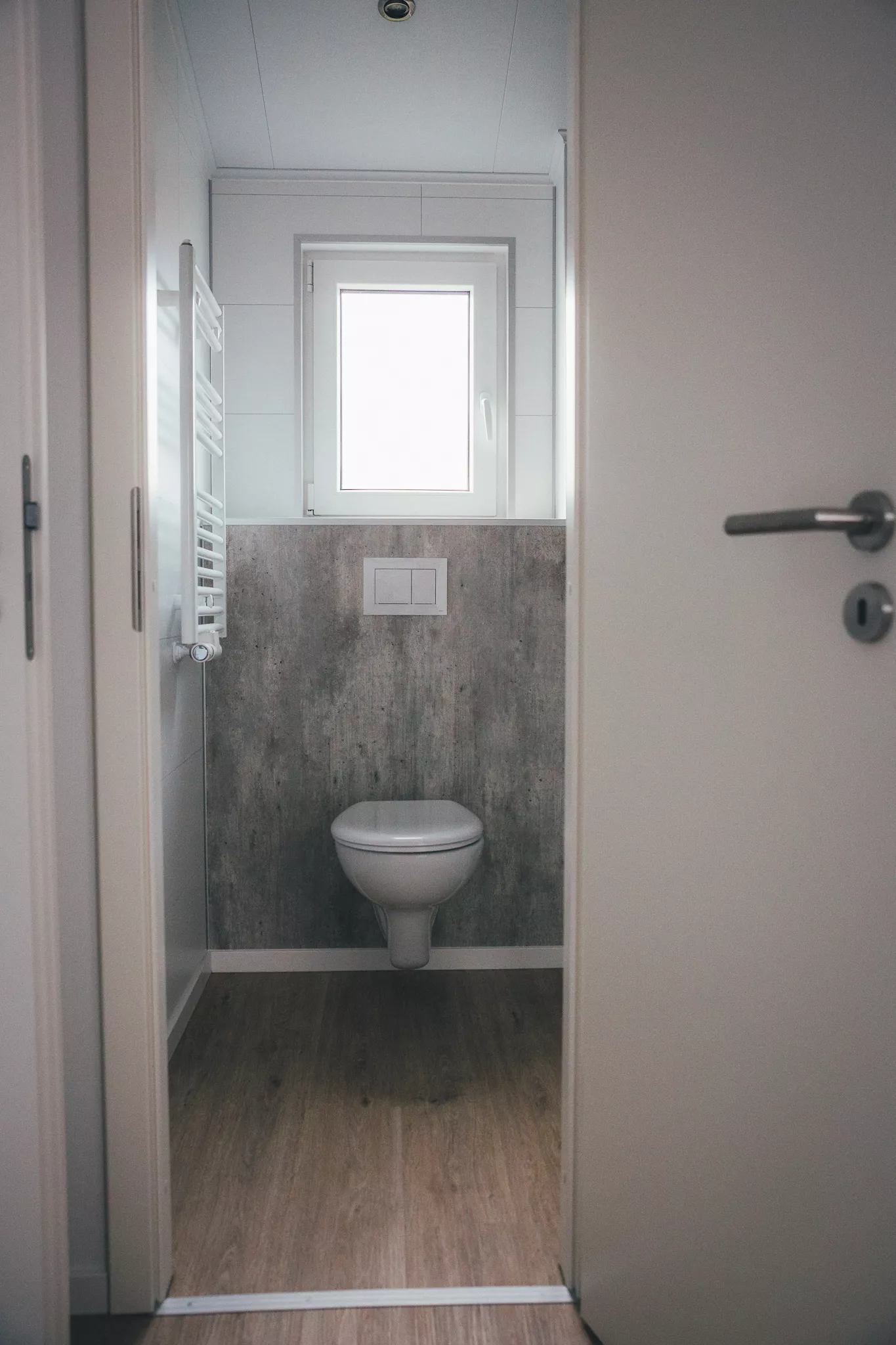 Kleines Bad mit wandhängendem WC, Fenster und Handtuchheizkörper
