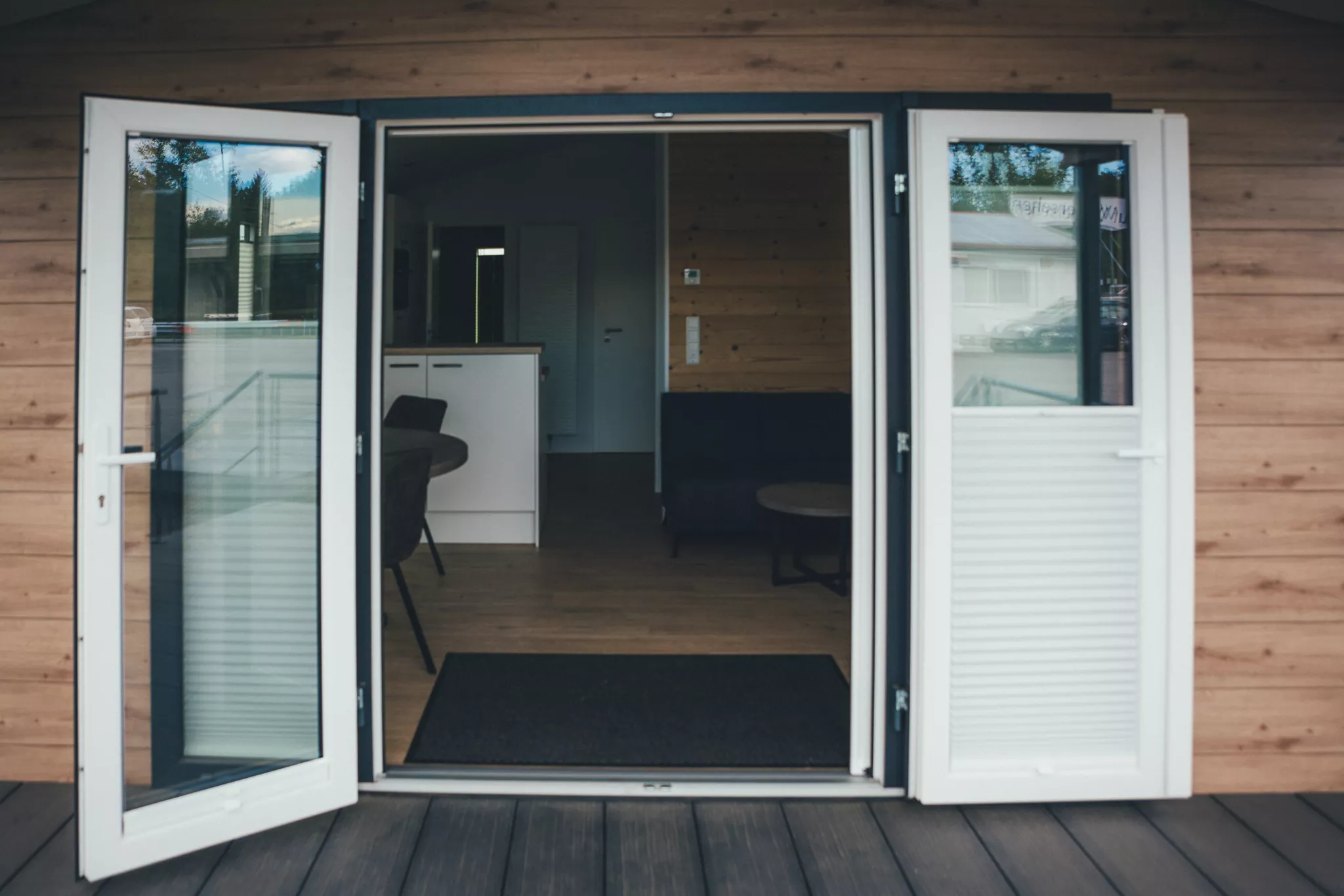 Offene Terrassentür mit Blick in den Wohnbereich des Tiny Houses