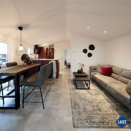 Wohnbereich mit Sofa, Esstisch und offener Küche